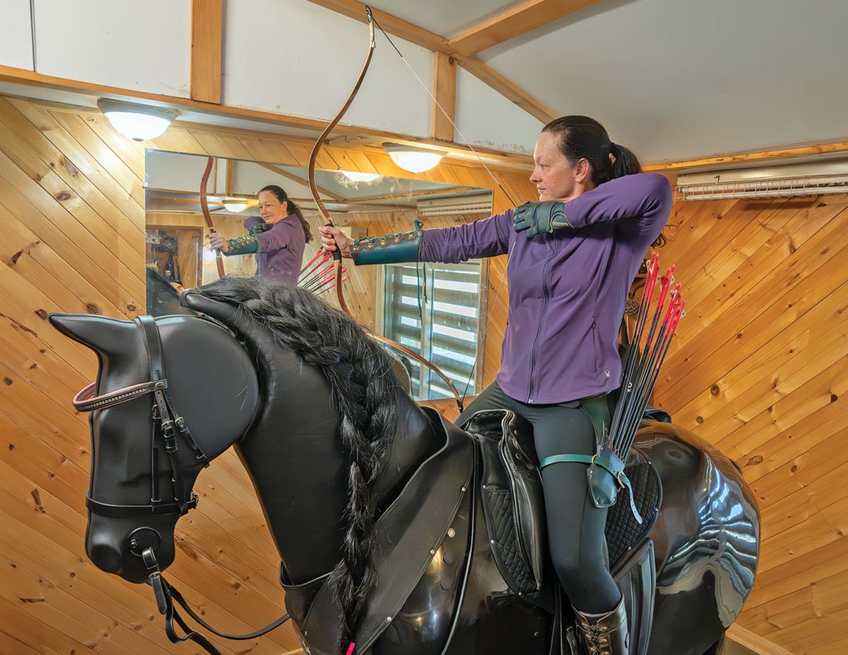 Mounted archery rider Anne Vavra training balance and seat position on RooElla dressage simulator.